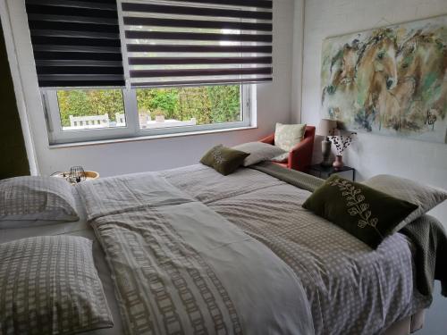 Un dormitorio con una cama grande y una ventana en Vakantiewoning Schouwenberg, en Swalmen
