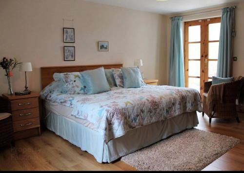 a bedroom with a large bed with blue pillows at Bluebell lake house in Enniskillen