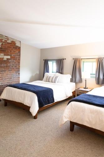a bedroom with two beds and a brick wall at The Penthouse- Heart of OTR w/Rooftop Terrace in Cincinnati