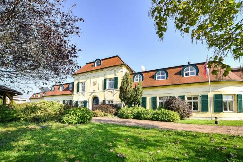 una gran casa blanca con techo rojo en Kaštieľ Sokoľany 