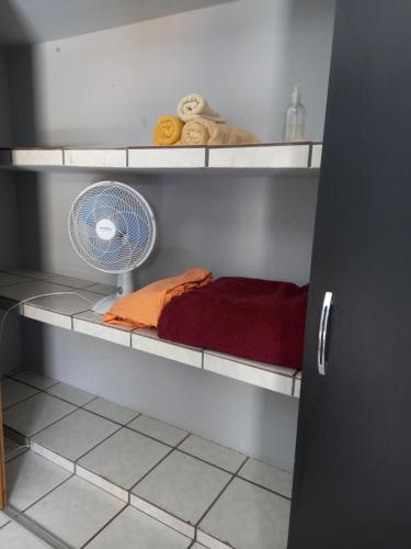 um quarto com uma ventoinha numa prateleira em Aero Hostel em Londrina