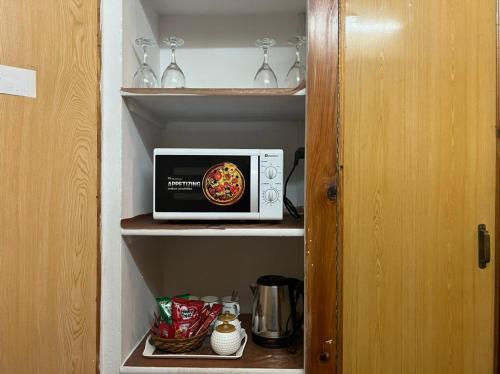 a small microwave sitting on a shelf in a kitchen at Urban Lodge in Abbottabad