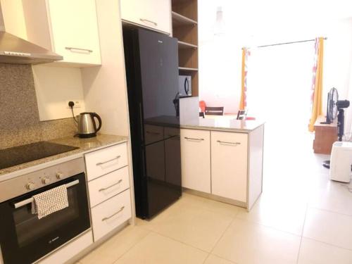 a kitchen with white cabinets and a stove top oven at Amazing 2 bedrooms with garden in Quatre Bornes