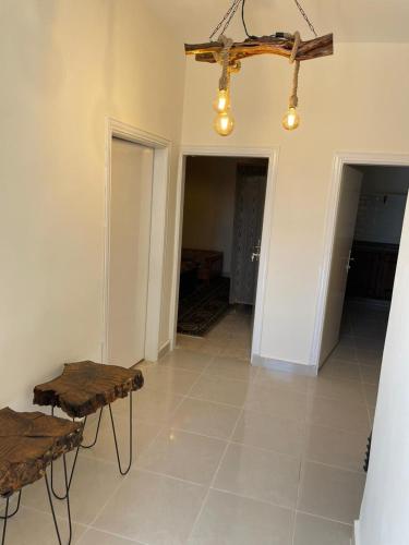 a living room with two tables and a ceiling at Wadi Al-Nakhil Hostel in Al Khuraybah