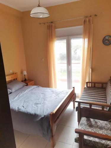 a bedroom with a bed and a large window at Cozy Nook Cottage in Faneroméni