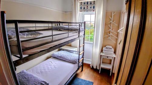 two bunk beds in a small room with a window at Gorgeous 4-Bed House in Bexhill-on-Sea sea views in Bexhill