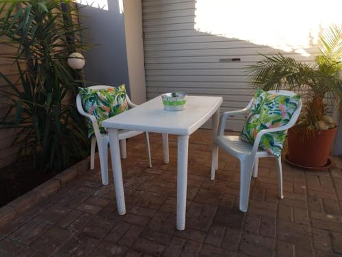 a white table and two chairs on a patio at Tehillah Guesthouse in Upington