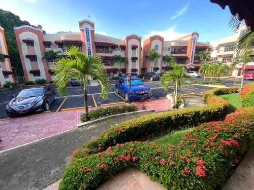 a parking lot with cars parked in front of a building at 1Dom Rep - Huge cozy 3 bedrooms - Electric transformer and Inverter- close to all transportation Jacobo Majluta - Residencial Paradise V Colina Arroyo 1 in Santo Domingo