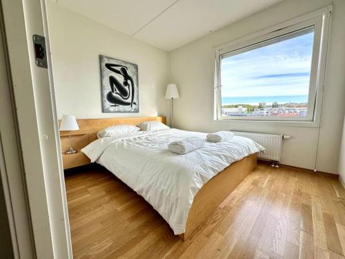 a bedroom with a large bed and a large window at Lovely central flat with great view in Oslo