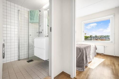 a white bathroom with a shower and a window at Lovely central flat with great view in Oslo
