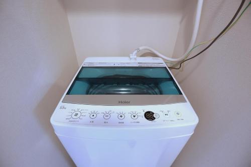 a washing machine sitting in a corner of a room at Shinjuku Ryokan Retreat丶Local Tokyo Experience & Short Trips Hub丶walk to Higahsi Shinjuku station YEoL in Tokyo