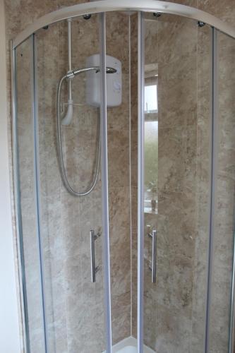 um chuveiro com uma porta de vidro na casa de banho em Large 7 double bedroom house with large driveway em Earlham
