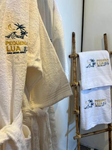 a pair of towels on a towel rack at Pequena Lua Flats - Península de Maraú in Barra Grande