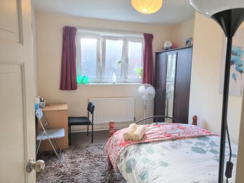 Schlafzimmer mit einem Bett, einem Schreibtisch und einem Fenster in der Unterkunft London Rooms in London