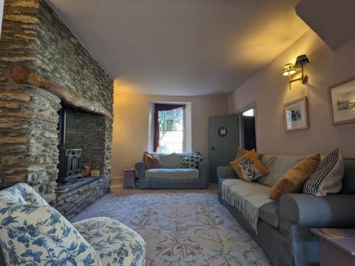 a living room with a couch and a stone fireplace at Seaside Georgian gem in Combe Martin