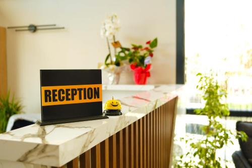 a laptop on a counter with a registration sign on it at Lenora Airport Hotel in Arnavutköy