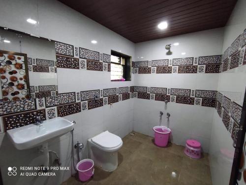 a bathroom with a toilet and a sink at NS Brothers Farm & Resort in Kolād