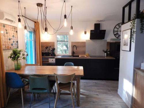 a kitchen and dining room with a wooden table and chairs at DOMAINE DU GOLF LACANAU Maison 3 ch, piscine 500 m², Golf, proche océan in Lacanau