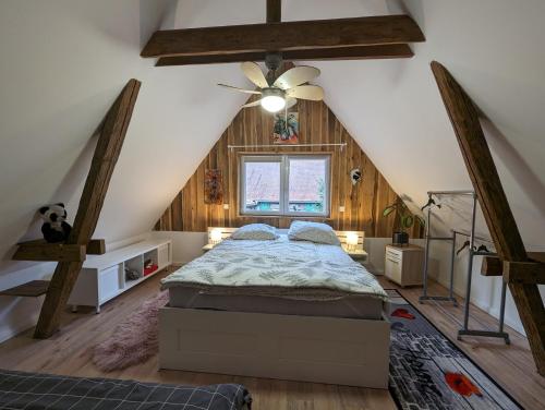 um quarto no sótão com uma cama e uma ventoinha de tecto em Ferienhaus Lilla em Nurembergue