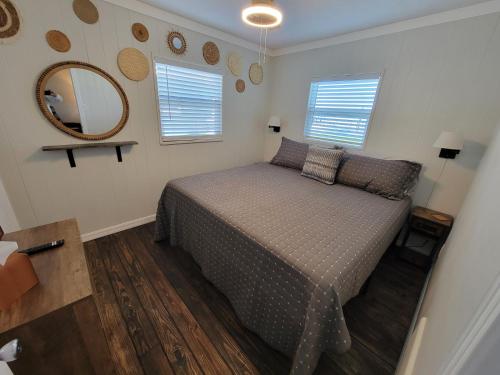 a bedroom with a bed and a mirror on the wall at Camp St. Cabanas Unit 3 on Lake Dora in Tavares