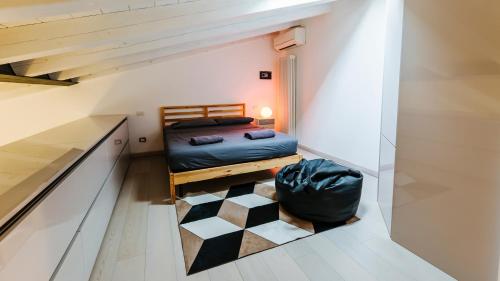 um pequeno quarto no sótão com uma cama e um piso em xadrez em Palazzo Romeo em Verona