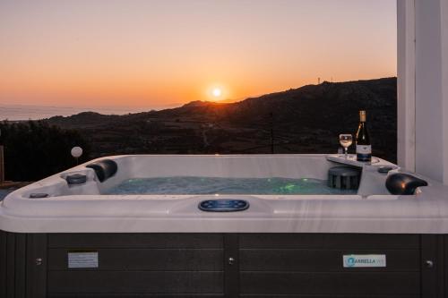 a bath tub with a bottle of wine and two glasses at Naxos Aethereal View in Kastraki Naxou