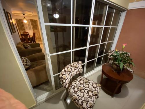 a living room with two chairs and a large window at 1Dom Rep - Huge cozy 3 bedrooms - close to all transportation Jacobo Majluta - Residencial Paradise V Colina Arroyo 1 in Santo Domingo