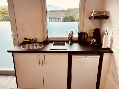 a kitchen counter with a sink and a window at Ké dodo sous le château !!! in Spa