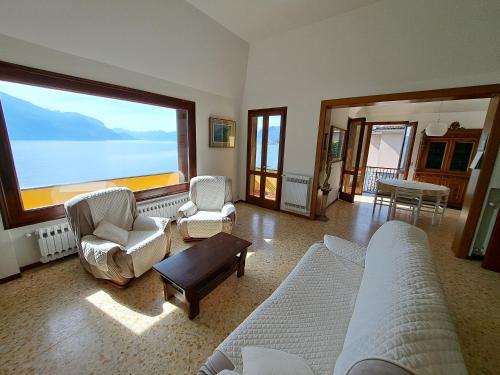 - un salon avec deux canapés et une grande fenêtre dans l'établissement Villa del Pescatore, à San Siro