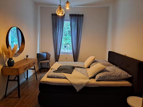 a bedroom with a bed and a desk and a window at Blick zum Brückentor in Traben-Trarbach