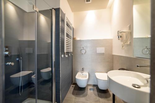 ein Badezimmer mit 2 WCs, einem Waschbecken und einer Dusche in der Unterkunft Ostia Holiday Sunset in Lido di Ostia