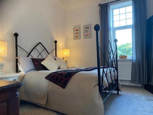 a bedroom with a bed and a window at Ashbourne Holiday Homes in Ashbourne