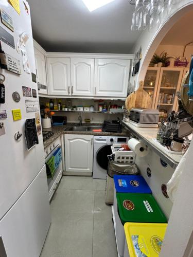 a kitchen with white cabinets and a white refrigerator at FLAT Surrounded by Nature WIFI & Pool & beach Nearby in Son Parc