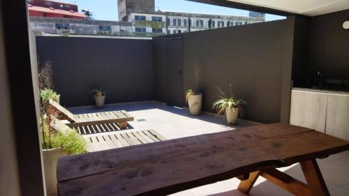 un banc en bois assis sur un balcon orné de plantes dans l'établissement Cafferata, à Rosario