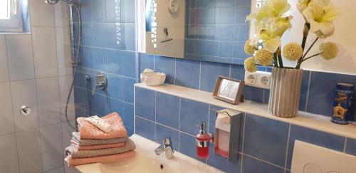 een badkamer met een wastafel en een blauwe tegelmuur bij Wichmannsberg II in Hameln