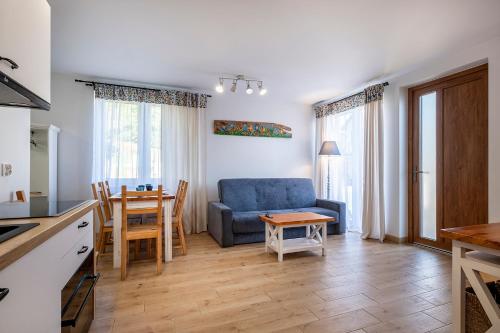 a living room with a blue couch and a table at 4 Pory Roku Apartamenty Domki Pokoje in Nadole
