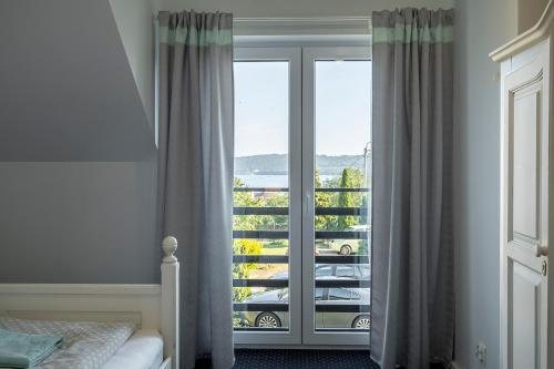 a bedroom with a large window with a balcony at 4 Pory Roku Apartamenty Domki Pokoje in Nadole