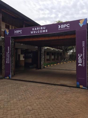 un ingresso a un edificio con un cartello di benvenuto viola di Lake Manyara Wildlife Lodge a Mto wa Mbu