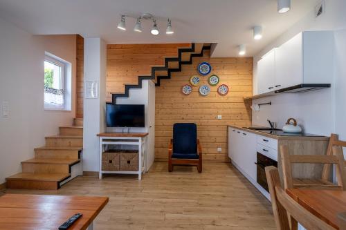 a kitchen with a staircase with a table and a chair at 4 Pory Roku Apartamenty Domki Pokoje in Nadole