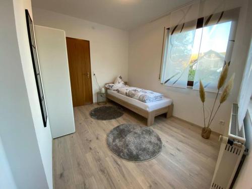 um pequeno quarto com uma cama e uma janela em Vali‘s Apartment One em Dettingen an der Erms