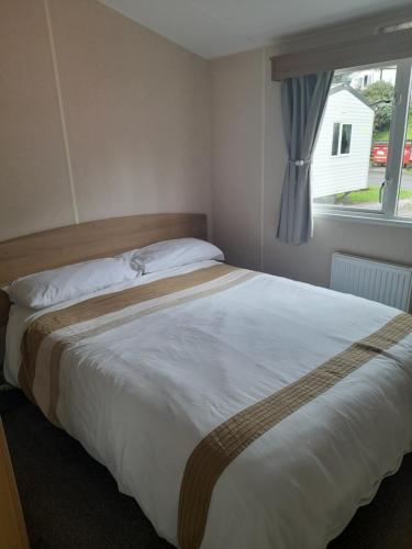 een slaapkamer met een groot bed en een raam bij Arnies Place Beacon Fell in Longridge