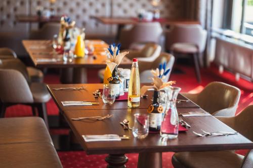 a row of tables in a restaurant with bottles on them at Hotel am Schlosspark Zum Kurfürst in Oberschleißheim