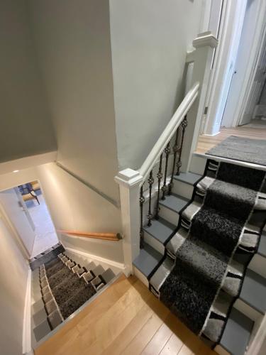a staircase with black and white carpeting and a stair case at Cozy apt in WEST NY, NEW JERSEY, at 2 bloks from bus stop-15 minutes 2NY 7MINUTES VIA NYWATERWAY FERRY-BETTER CAN'T BE!! in West New York