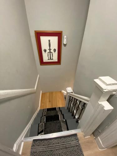 a stairway with a stair case and a picture on the wall at Cozy apt in WEST NY, NEW JERSEY, at 2 bloks from bus stop-15 minutes 2NY 7MINUTES VIA NYWATERWAY FERRY-BETTER CAN'T BE!! in West New York