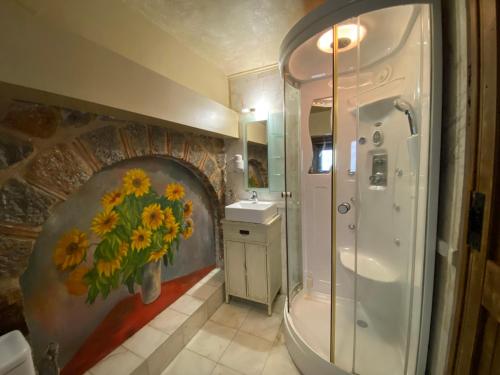 a bathroom with a shower and a vase of flowers on the wall at Alexandros Guesthouse in Arachova