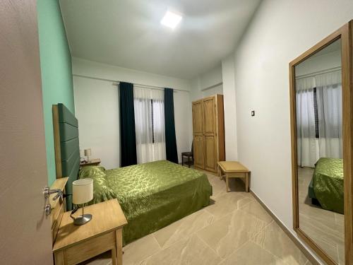 um quarto com uma cama verde e um espelho em Residence Kalispera em Scalea