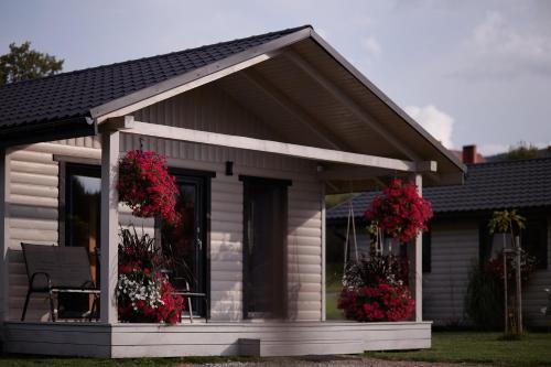 a small house with red flowers on the porch at Lawendowy Zakręt in Ustrzyki Dolne