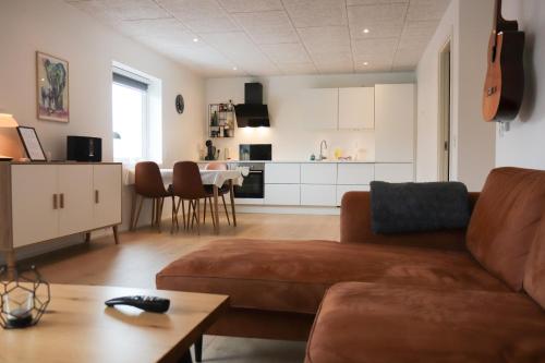 a living room with a couch and a table at BRAND NEW FLAT IN CENTRAL KLAKSVÍK in Klaksvík