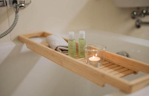 een houten plank met handdoeken en een kaars in de badkamer bij Zentral Smart Apartment in Zwickau