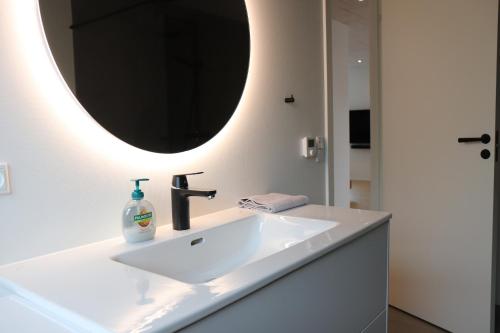 a bathroom with a white sink and a mirror at BRAND NEW FLAT IN CENTRAL KLAKSVÍK in Klaksvík